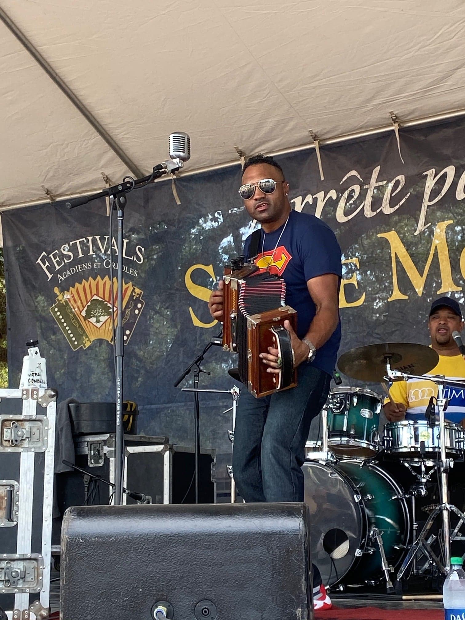 A musician plays the accordion on stage at a festival.